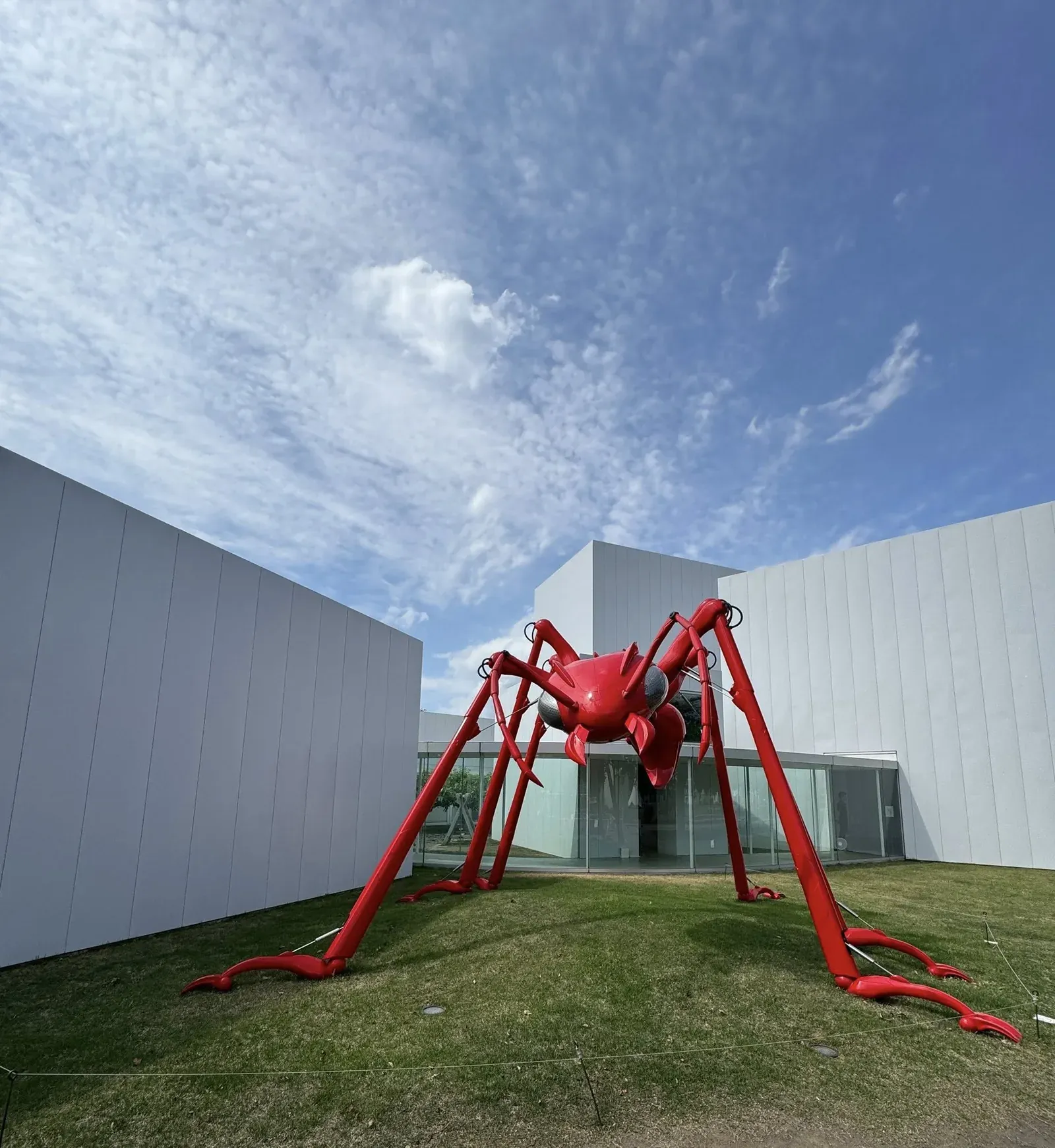 青森十和田市現代美術館 戶外裝置 — 紅色巨型蜘蛛雕塑與藍天